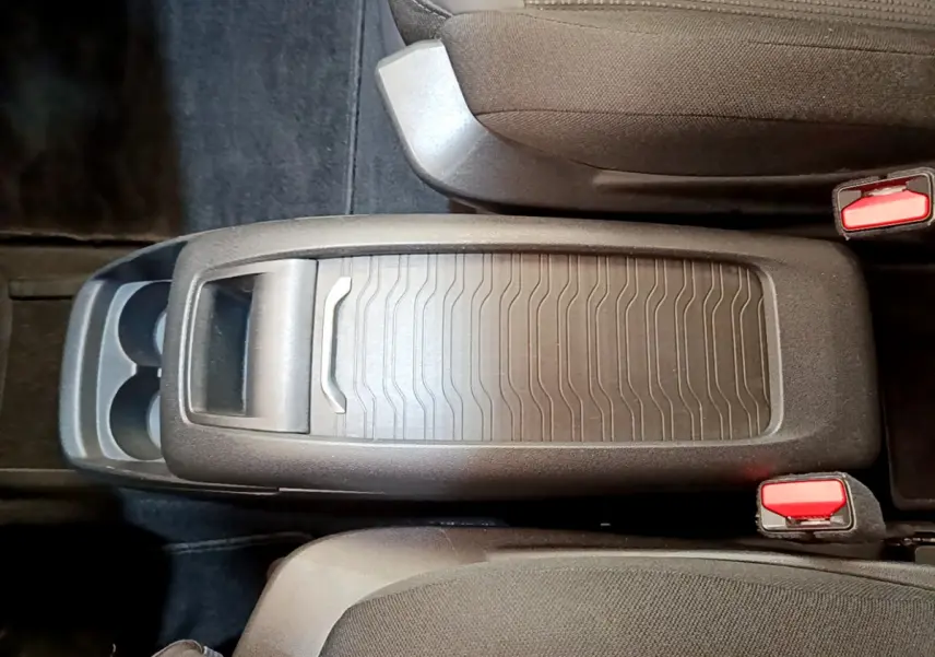 Vue plongeante sur la console centrale noire du Citroën Grand C4 Spacetourer avec porte-gobelets et sièges gris foncé.