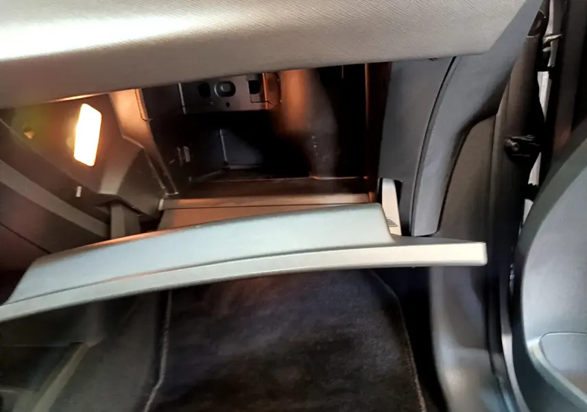 Ouverture du rangement réfrigéré gris clair côté passager dans l'habitacle du Citroën Grand C4 SpaceTourer gris foncé.