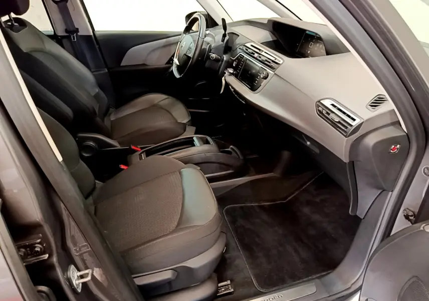 Vue intérieure côté conducteur du Citroën Grand C4 Spacetourer gris foncé, avec tableau de bord et sièges noirs.