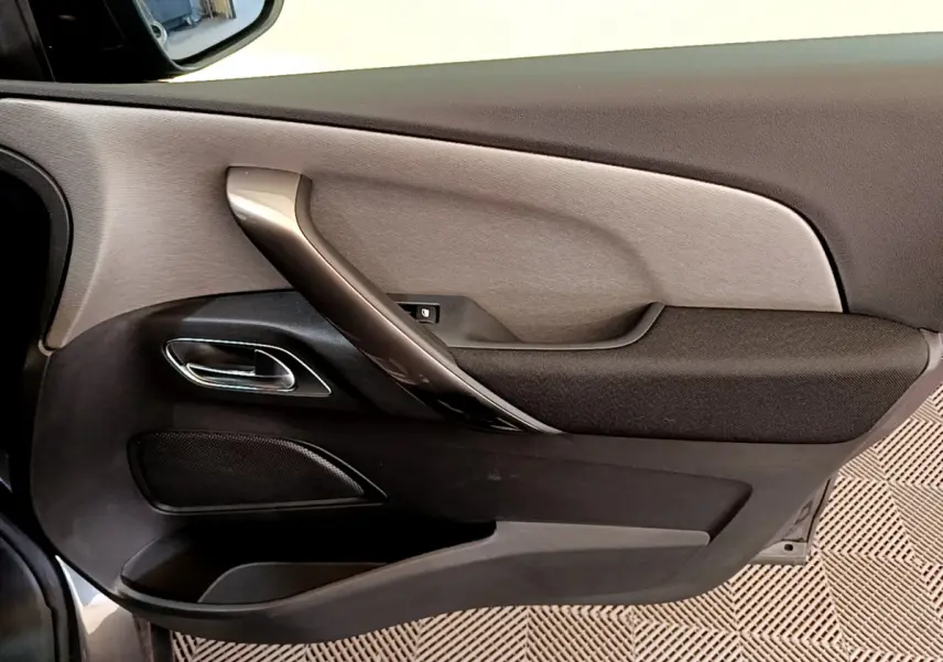 Vue rapprochée de la porte côté gauche du Citroën Grand C4 SpaceTourer gris foncé, avec poignée argentée et garniture noire.