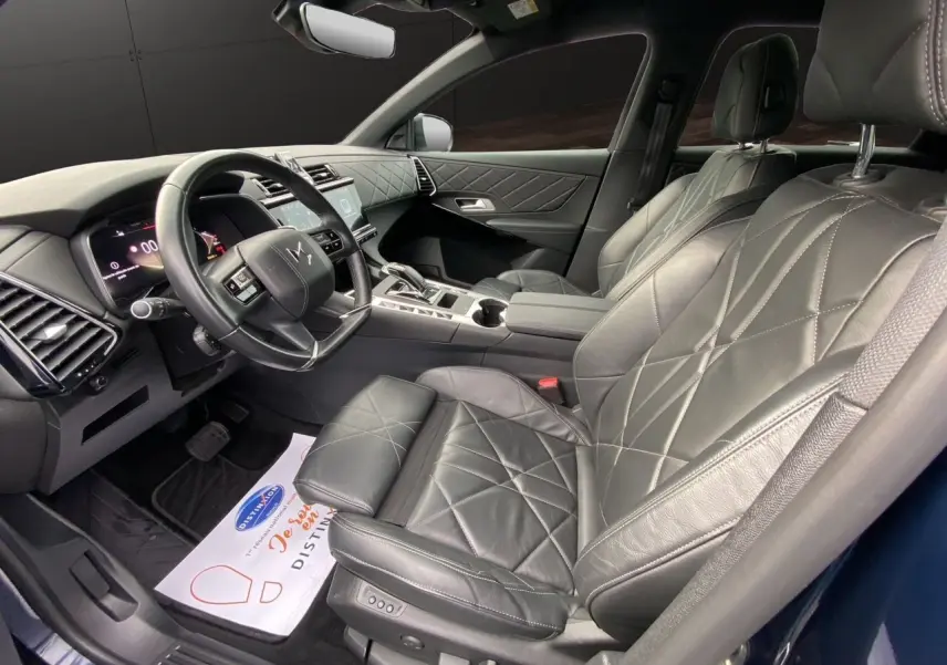 Vue intérieure côté conducteur du DS7 2024 en sellerie cuir noir électrique avec tableau de bord et console moderne.