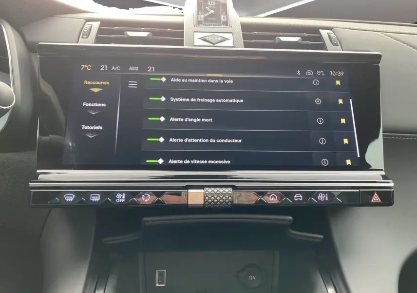 Écran tactile central du DS7 2024 avec montre BRM au-dessus, affichant les aides à la conduite dans un intérieur cuir noir.