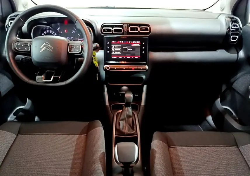 Vue intérieure avant du Citroën C3 Aircross avec tableau de bord noir et écran tactile central lumineux.