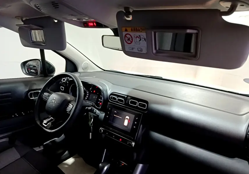Vue intérieure côté conducteur du tableau de bord noir du Citroën C3 Aircross avec écran tactile et volant multifonctions.