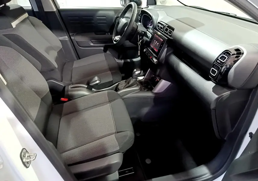 Intérieur avant droit du Citroën C3 Aircross blanc 2019 avec sièges tissu noirs et écran tactile central.