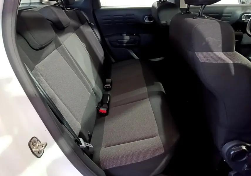 Vue intérieure côté gauche montrant la banquette arrière noire du Citroën C3 Aircross blanc de 2019.