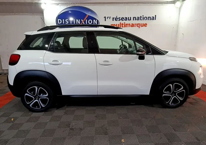Profil droit d'un Citroën C3 Aircross blanc avec toit noir et jantes distinctives en concession.