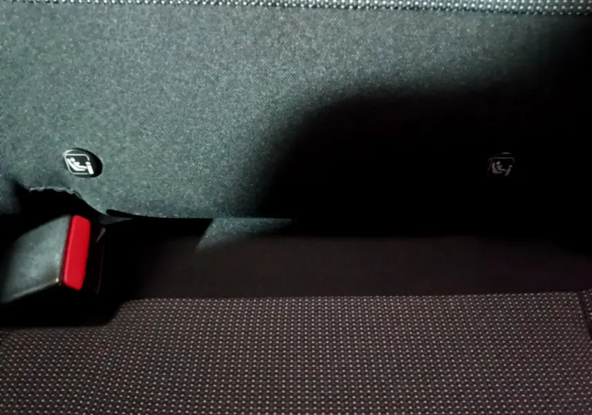 Gros plan sur la banquette arrière noire du Citroën C3 Aircross avec attaches Isofix visibles et boucle de ceinture rouge.