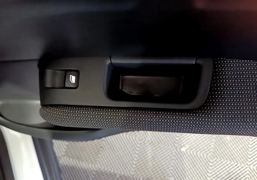 Poignée intérieure et bouton de lève-vitre sur la portière côté droit d’un Citroën C3 Aircross blanc.