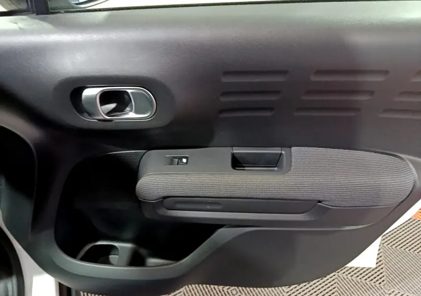 Gros plan sur la porte intérieure côté gauche noire et tissu gris du Citroën C3 Aircross blanc 2019.