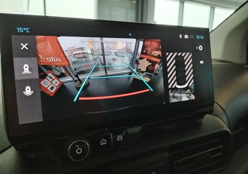 Écran intérieur du Citroën Berlingo blanc 2025 montrant la caméra de recul avec lignes de guidage colorées.