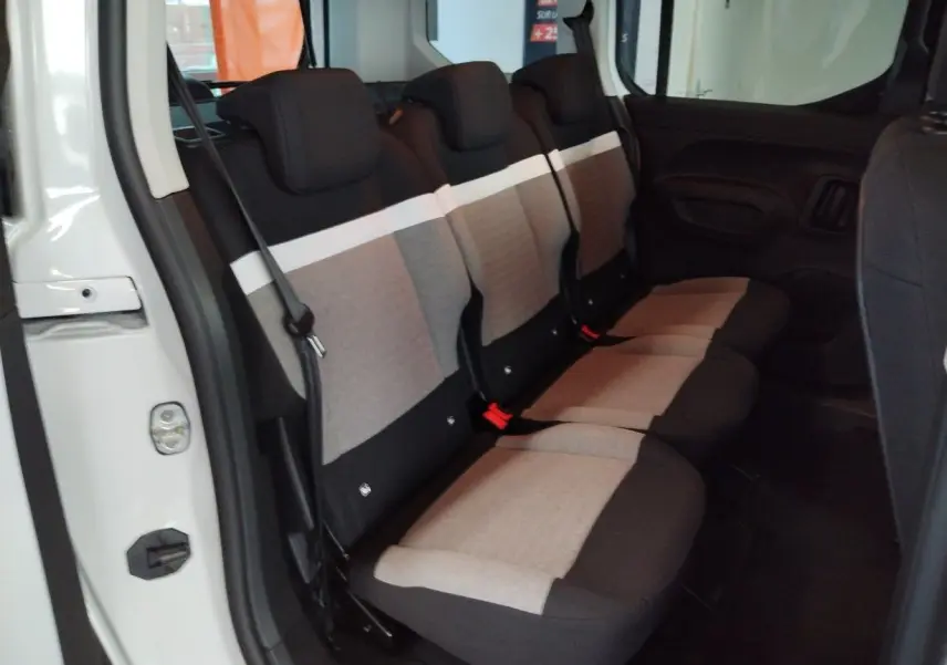 Vue intérieure côté droit sur les trois sièges individuels arrière gris et noir du Citroën Berlingo blanc 2025.