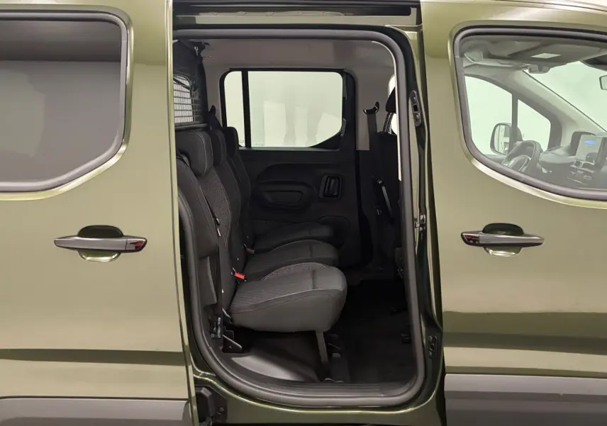Vue latérale gauche d’un Peugeot Rifter Sirkka Green 2026 avec porte coulissante ouverte et sièges individuels en tissu visibles.