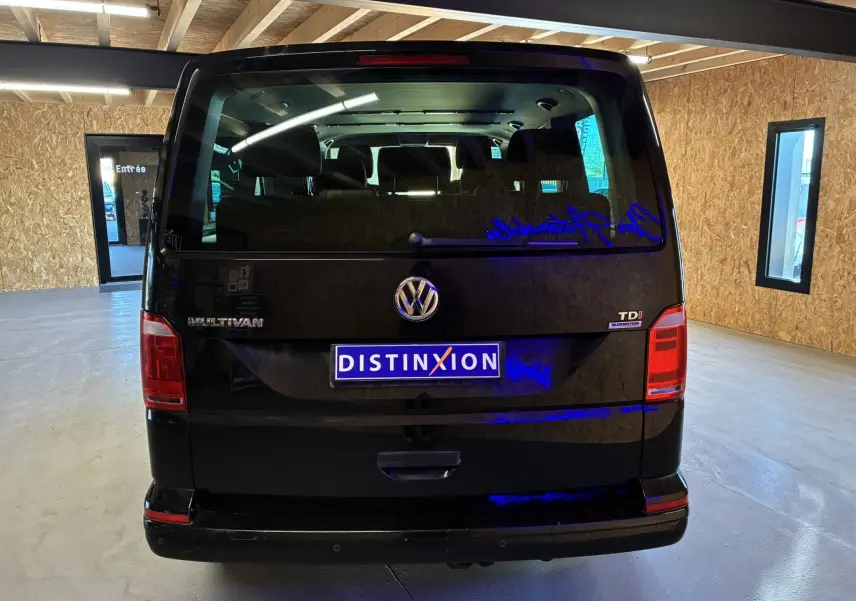 Vue arrière d’un Volkswagen Multivan T6 noir de 2015, avec badge TDI et plaque Distinxion visible en intérieur.