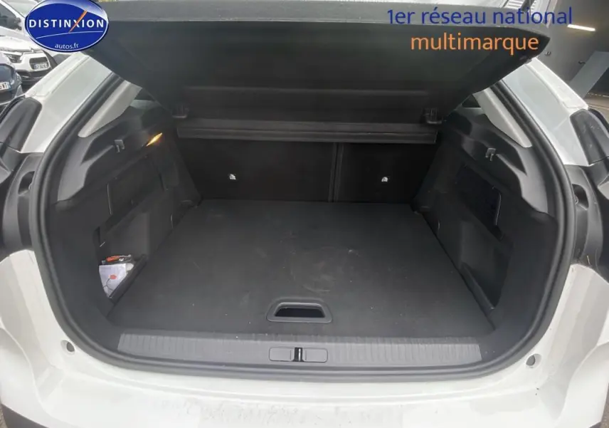 Coffre ouvert d'une Citroën C4 blanche 2022, vue arrière montrant l'espace de chargement vide et la sellerie noire.