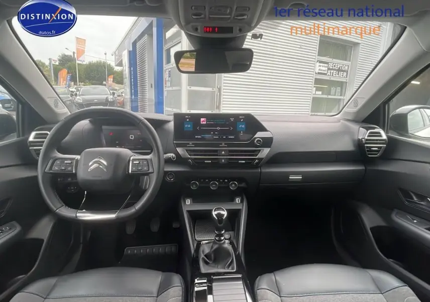 Intérieur du Citroën C4 blanc 2022, vue frontale du tableau de bord avec écran tactile et boîte manuelle.