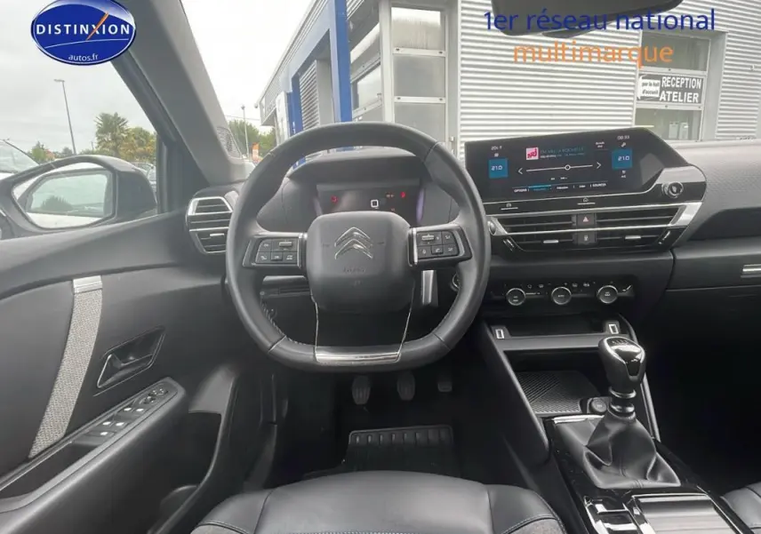 Intérieur noir de la Citroën C4 2022 Diesel, vue de face sur le volant, tableau de bord et levier de vitesse manuel.