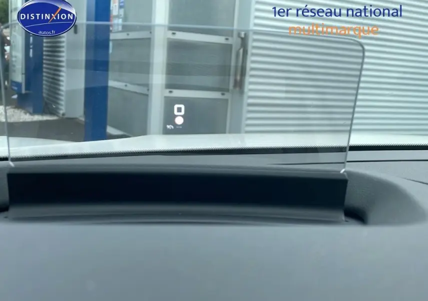 Affichage tête haute en fonctionnement sur le tableau de bord d'une Citroën C4 blanche, vue intérieure avant.