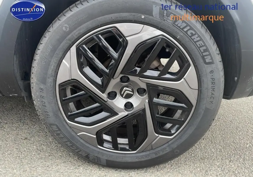 Gros plan sur la jante alliage 18 pouces noire et grise d'une Citroën C4 blanche Diesel 2022.