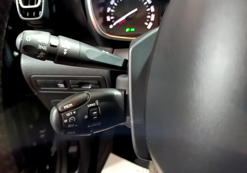 Gros plan sur les commandes au volant côté gauche du Citroën C3 Aircross noir, montrant les fonctions régulateur et limiteur de vitesse.