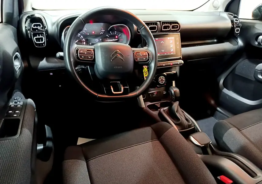 Intérieur noir du Citroën C3 Aircross 2019 vu côté conducteur, volant cuir et écran tactile central visible.
