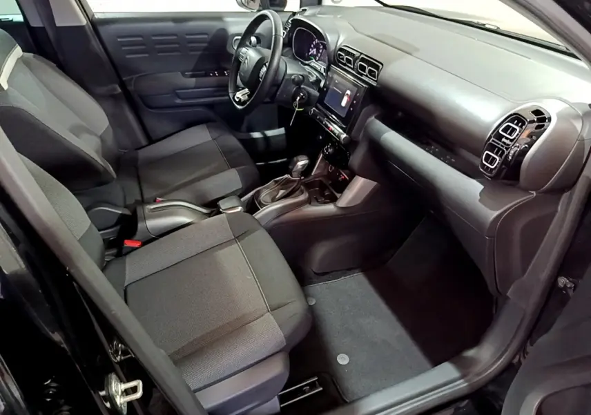 Intérieur noir du Citroën C3 Aircross vu côté conducteur, avec tableau de bord moderne et écran tactile central.