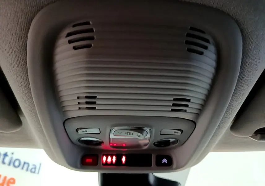 Vue en gros plan du plafonnier gris clair avec commandes d’éclairage et alertes rouges à l’intérieur d’un Citroën C3 Aircross noir.