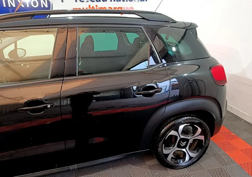 Vue latérale côté gauche d'un Citroën C3 Aircross noir brillant, mettant en valeur les jantes originales et les poignées de porte.