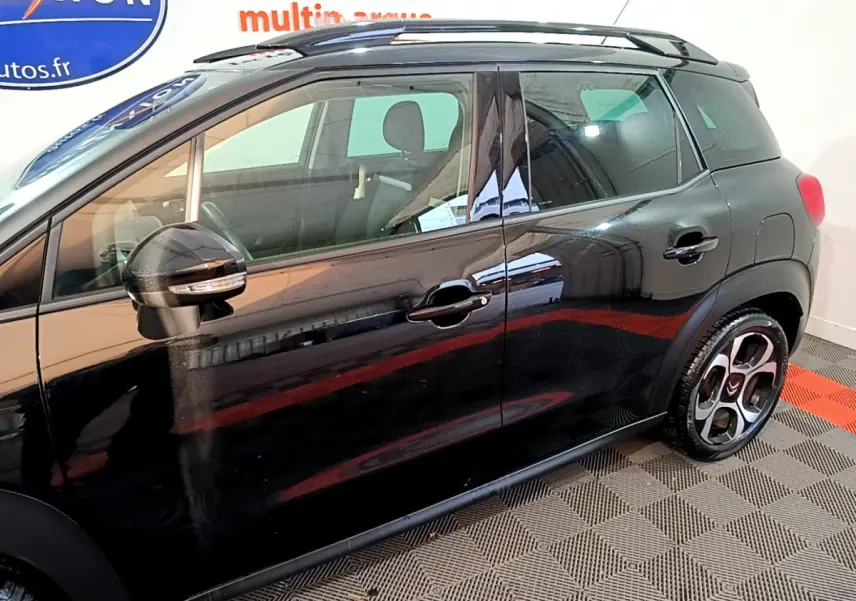 Profil côté gauche du Citroën C3 Aircross noir 2019 avec barres de toit et jantes distinctives.