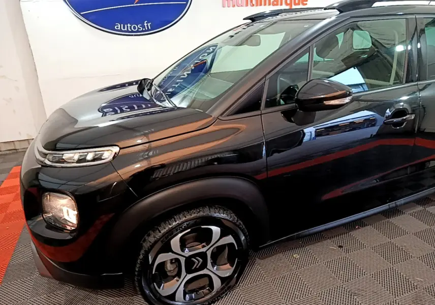 Vue 3/4 avant gauche d'un Citroën C3 Aircross noir brillant avec jantes alliage et rétroviseurs ton caisse.