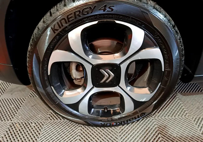 Gros plan sur la jante alliage noire et argentée avec logo Citroën, montée sur pneu Hankook d'un C3 Aircross noir.