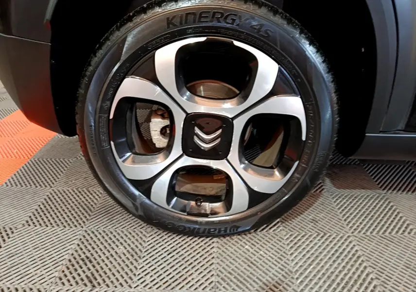Gros plan sur la roue avant gauche noire d'un Citroën C3 Aircross 2019 avec jante alliage au design moderne.