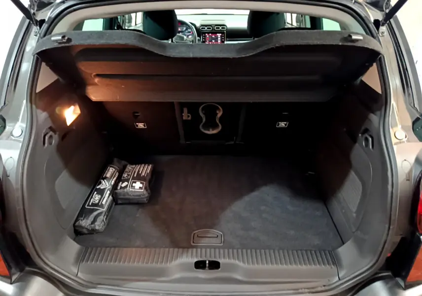 Coffre ouvert d'une Citroën C3 Aircross noir, vue arrière montrant l'espace de chargement et la tablette de séparation.