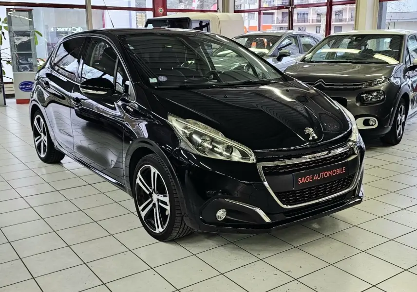 PEUGEOT 208 GT-LINE noir vue 3/4 avant droit en showroom avec jantes alliage et calandre chromée.