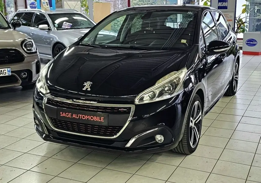 Peugeot 208 GT-LINE noir vue 3/4 avant droit en showroom avec jantes alliage et phares halogènes.