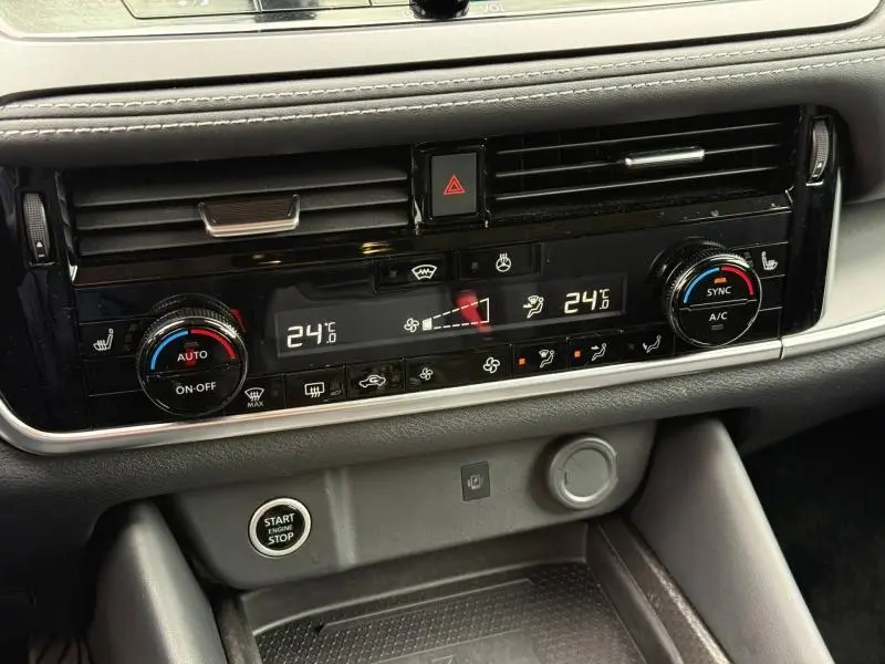 Détail du tableau de bord du Nissan Qashqai 2025 montrant la climatisation bi-zone avec commandes tactiles et bouton start/stop.