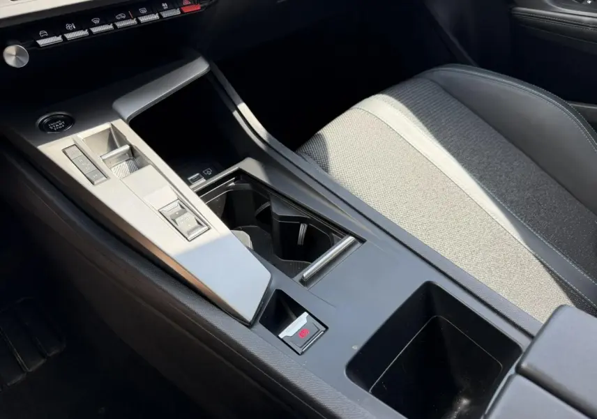 Vue rapprochée de la console centrale et siège avant gris clair avec surpiqûres sur la Peugeot 308 2025.