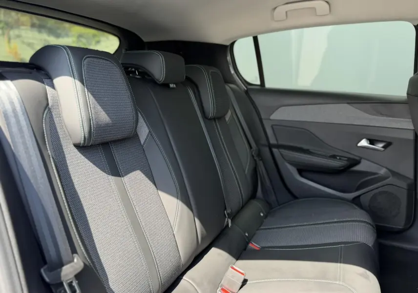 Vue latérale droite des sièges arrière en tissu et cuir noir de la Peugeot 308 1.5 BlueHDI 130 Allure 2025.