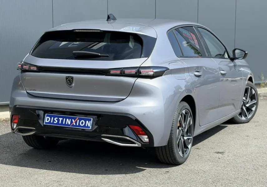 Vue 3/4 arrière droite de la Peugeot 308 gris Artense avec jantes alliage 17'' et bandeau noir brillant arrière.