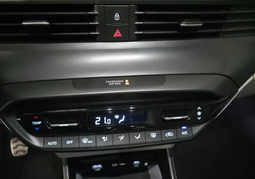 Vue rapprochée du panneau de climatisation automatique noir du Hyundai BAYON 2025 avec affichage digital à 21°C.