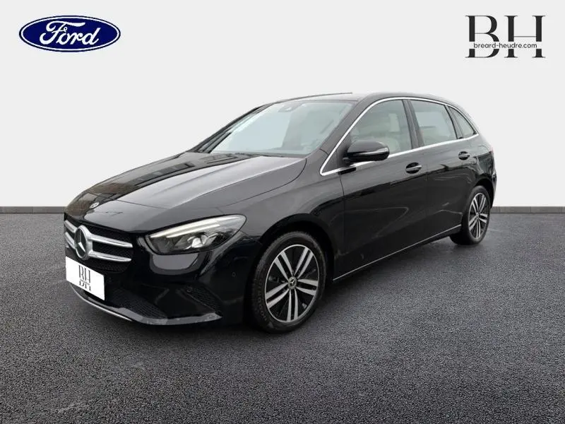 Mercedes Classe B 250 e noire cosmos métallisé vue 3/4 avant avec jantes alliage et phares LED allumés.
