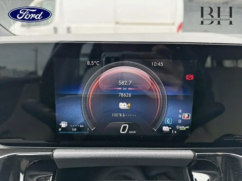 Tableau de bord numérique affichant l'autonomie et la vitesse, intérieur d'une Mercedes Classe B noire vue de face.