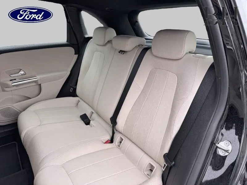 Vue intérieure côté droit des sièges arrière beige clair d'une Mercedes Classe B 250 e 2021 avec portières noires.
