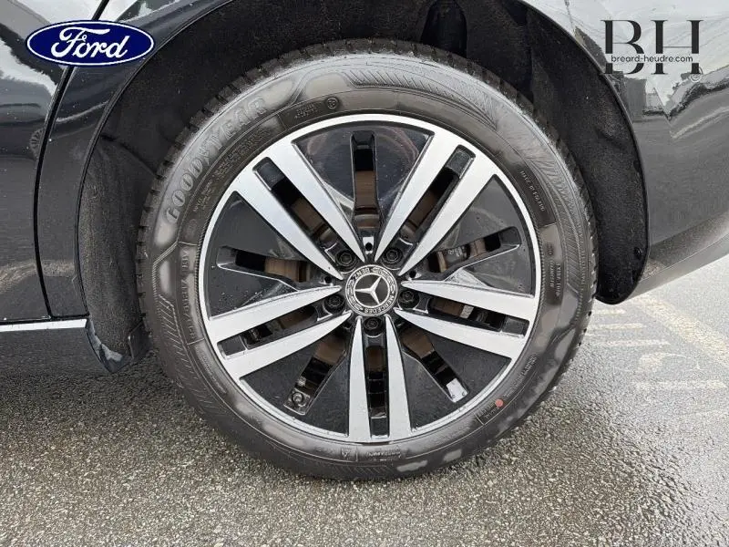 Gros plan sur la jante alu bicolore et pneu Goodyear d'une Mercedes Classe B noire cosmos métallisé.