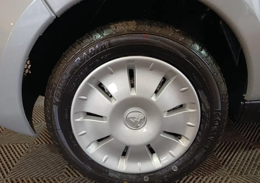 Gros plan sur la roue avant droite gris clair de l'AIXAM AMBITION 0.5 CITY PACK 2026 avec jante et logo central visible.