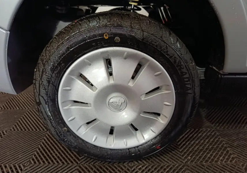 Gros plan sur la roue avant droite grise d’une Aixam Ambition 0.5 City Pack 2026 avec jante en plastique argenté.