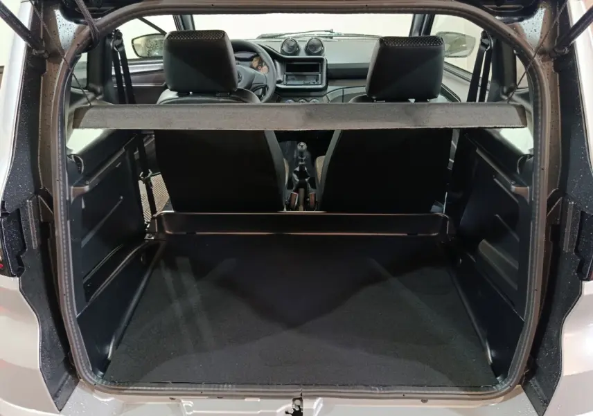 Vue arrière ouverte sur le coffre et l'intérieur de l'AIXAM Ambition gris clair 2026 avec tableau de bord et sièges noirs visibles.