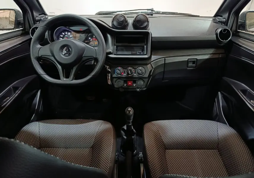 Vue intérieure frontale du tableau de bord et volant de l'AIXAM Ambition 0.5 City Pack avec sièges gris à motifs.