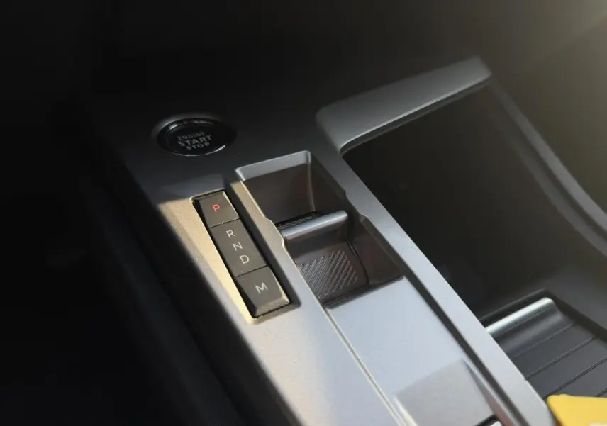 Gros plan sur la console centrale grise avec sélecteur de boîte automatique et bouton start/stop dans une Peugeot 308 noire.