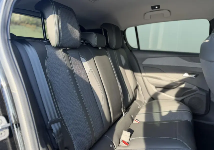 Vue intérieure des sièges arrière en cuir et tissu gris foncé de la Peugeot 308 2025, côté droit ouvert.